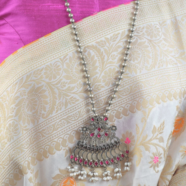 The dashing silver pendant along with long silver beads chain is beyond beautiful, especially the pearl on the bottom, perfect for ladies. It's charming pendant with pink stone will give you intricate and elegance to your look When you will carry it.